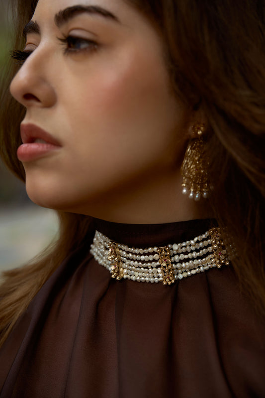 Woman wearing the Scarlet multi-strand pearl choker necklace with floral gold detailing and ruby-red accents